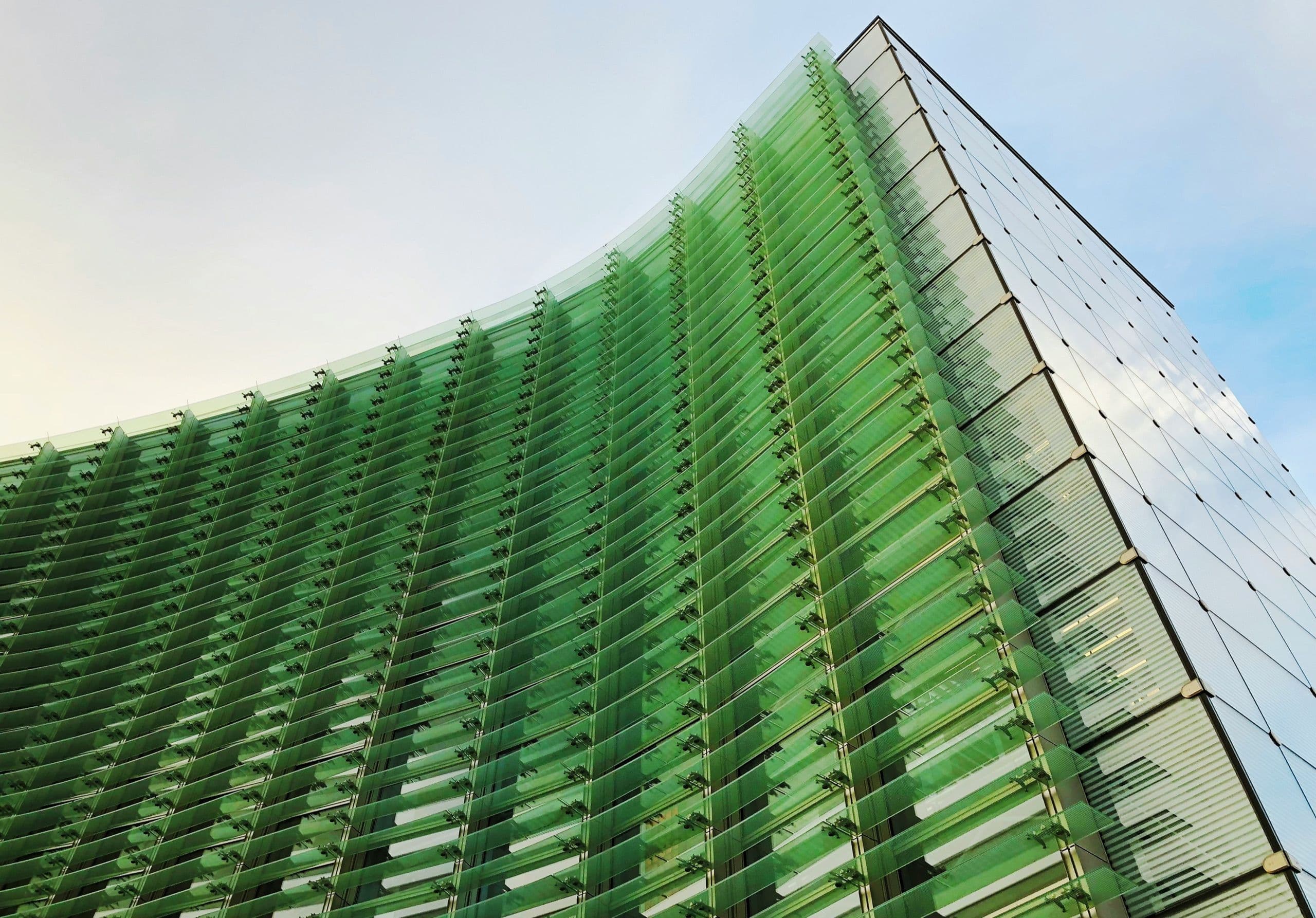 A high-rise clad in green glass louvres
